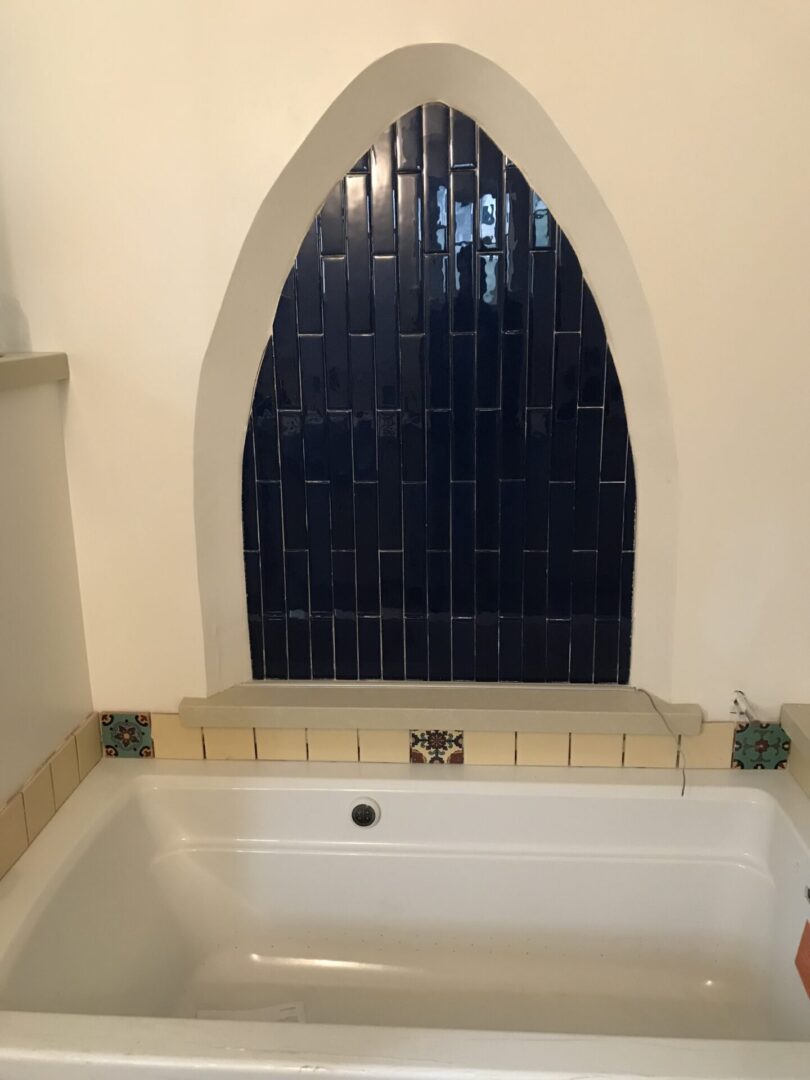 A bathtub with a window above it in the middle of the room.