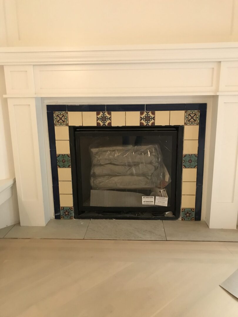 A fireplace with tile surround and mantle.